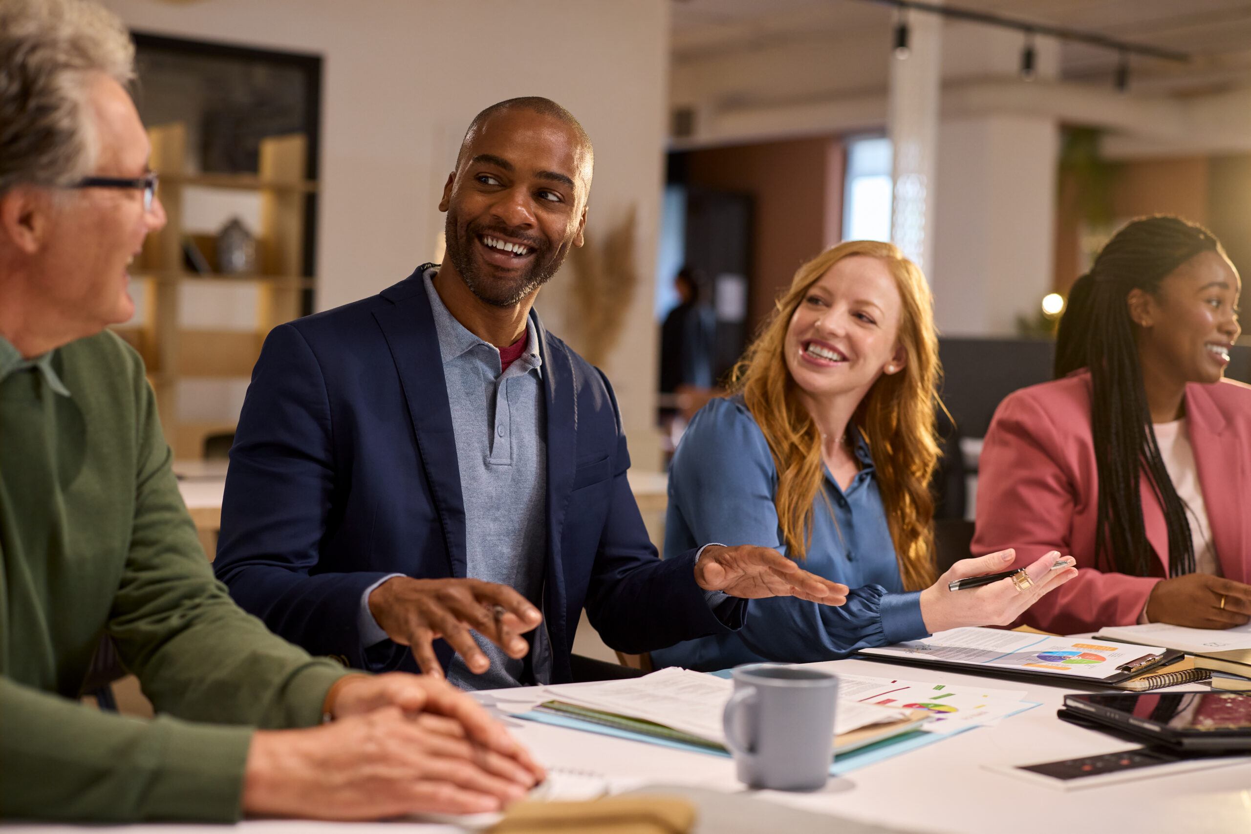 Four adults are seated around a table in a leadership skill development program.